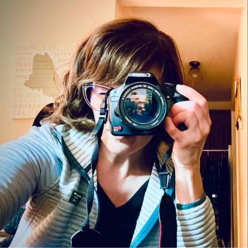 Photographer Laura Michaud holding camera up to her eye to take a picture